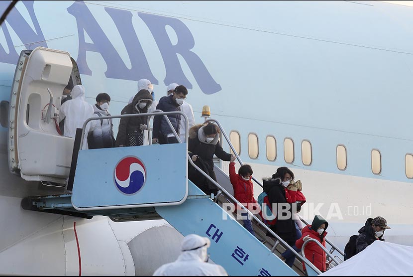 Warga Korea Selatan yang dievakuasi dari Kota Wuhan turun dari pesawat setelah mendarat di  Gimpo International Airport, Gimpo, Korea Selatan, Jumat (31/1).