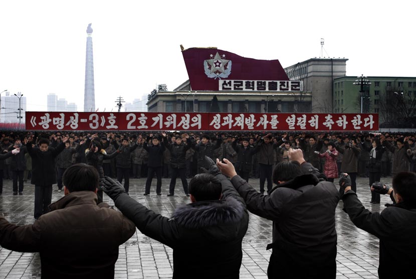  Warga Korea Utara melambaikan tangan saat merayakan keberhasilan peluncuran roket Unha-3 di lapangan Kim Il Sung di Pyongyang, Korea Utara, Jumat (14/12). (AP/Jon Chol Jin)  