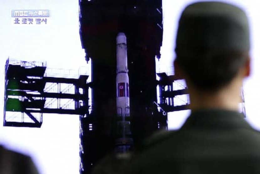 Warga Korsel  melalui tv layar lebar, menyaksikan peluncuran roket jarak jauh milik Korea Utara.