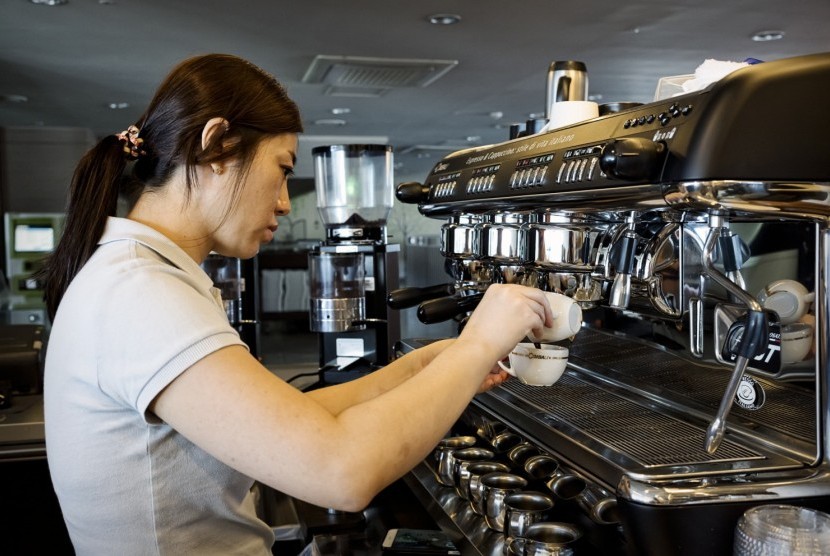 Seorang wanita sedang membuat kopi espresso 