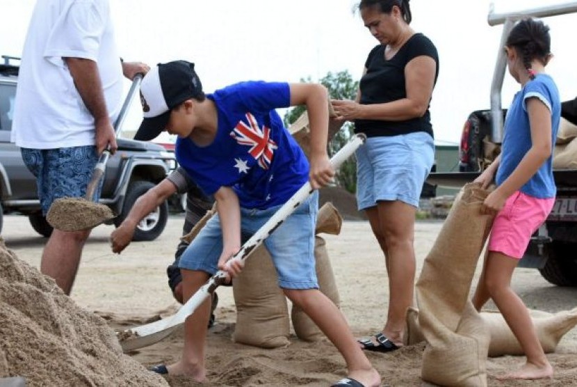 Warga Kota Bowen memasukkan pasir ke karung sebagai persiapan menghadapi Siklon Tropis Debbie, Senin 27 Maret 2017.