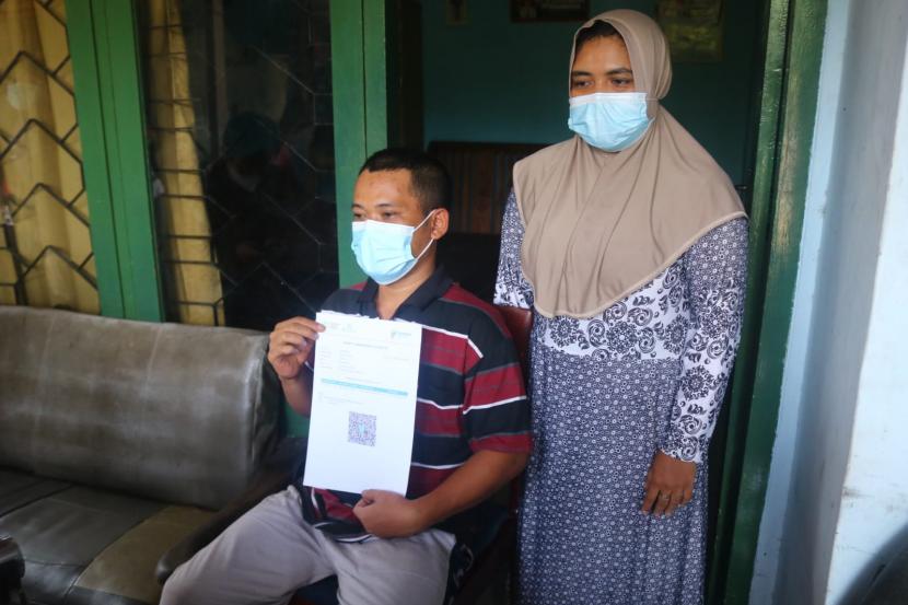 Warga Kota Malang Joko Santoso (duduk) bersama sang istri menceritakan pengalaman kebutaannya setelah mendapatkan vaksin AstraZeneca, Kamis (2/12). 