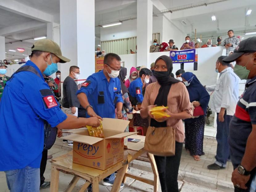 Warga Kota Sukabumi antri membeli minyak goreng dalam operasi pasar di Pasar Pelita Kota Sukabumi, Sabtu (26/2/2022).