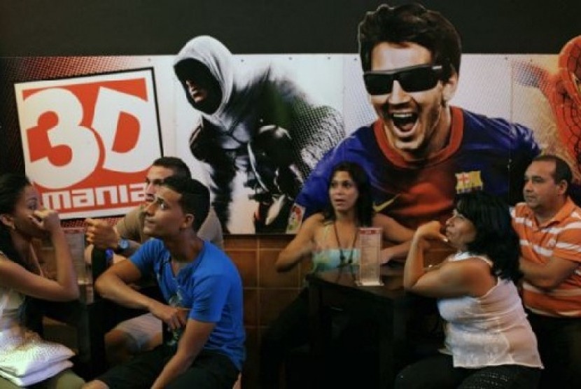 Warga Kuba tengah menunggu sebuah pemutaran film di dekat gambar pesepakbola Lionel Messi di gedung bioskop privat 