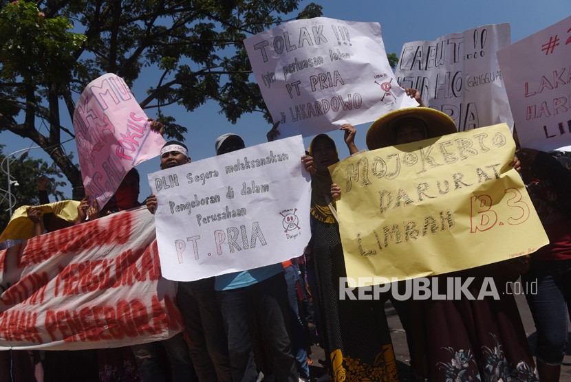 Warga Lakardowo membentangkan spanduk dan poster saat aksi peringatan Hari Bumi di depan kantor Gubernur Jawa Timur, Surabaya, Jawa Timur, Senin (30/4). 