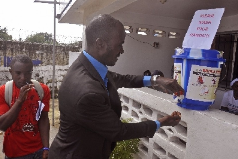 Warga Liberia tengah mengantri untuk mencuci tangan. Sesuai anjuran WHO, kebersihan menjadi prioritas penting guna mencegah penyebaran Ebola.