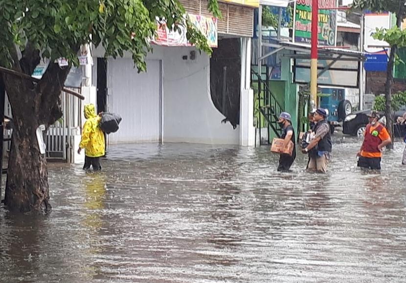 Warga Lingkungan Kelurahan Tambakrejo beraktivitas di tengah genangan banjir yang masih setinggi paha orang dewasa, Senin (8/2). Hujan yang terus mengguyur wilayah Kota Semarang mengakibatkan genangan banjir di sejumlah tempat belum surut.