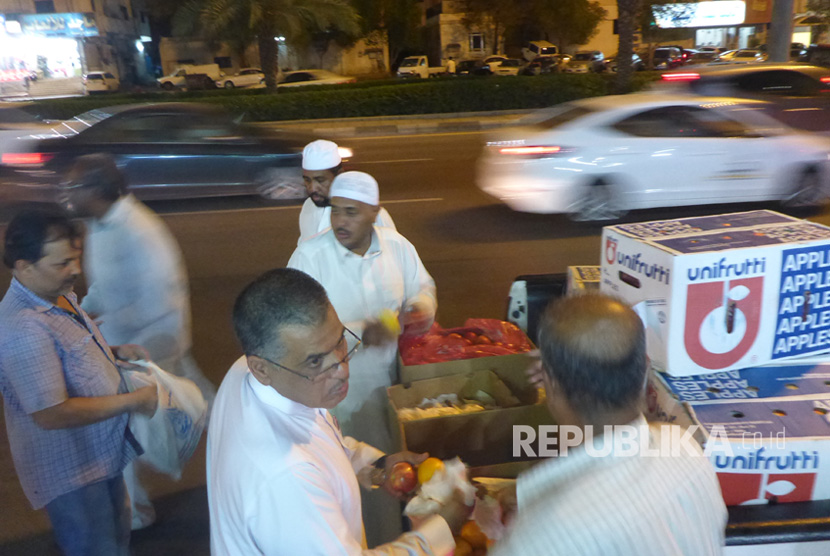 Warga lokal membagikan buah-buahan gratis kepada jamaah haji dan warga sekitar di Makkah, Selasa malam (22/8). 