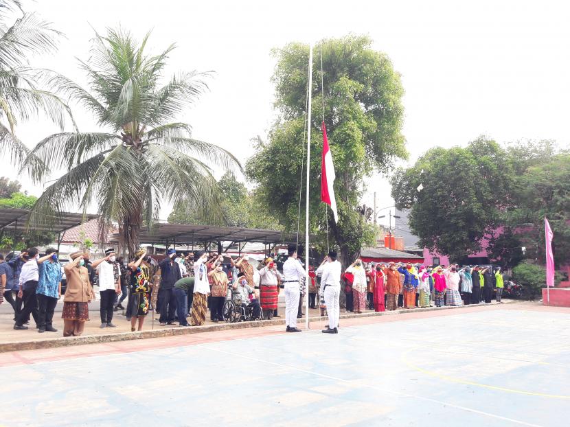 Warga Malaka Jaya, Jakarta Timur mengikuti upacara pengibaran bendera dengan memakai baju adat, Senin (17/8).