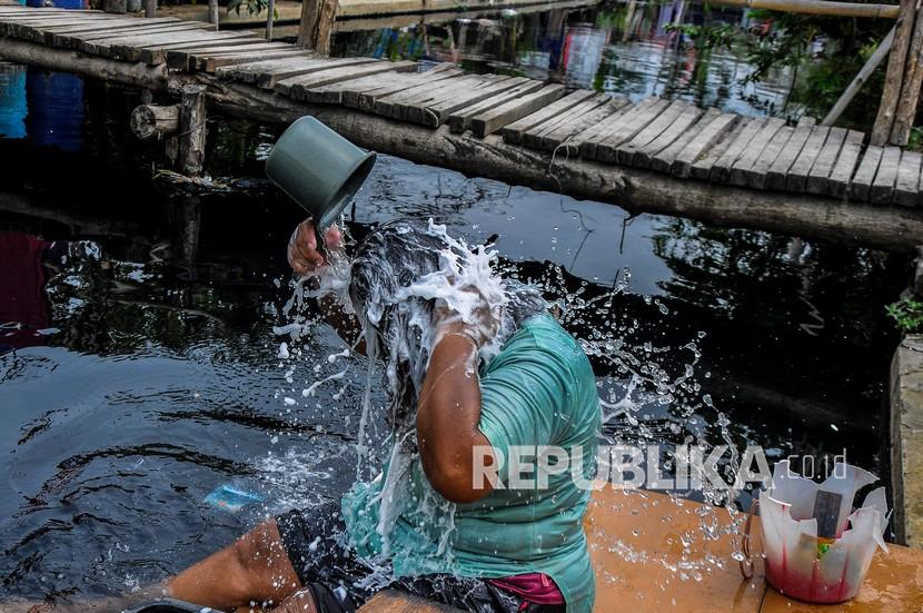 Warga mandi menggunakan air Kali Cilemahabang yang tercemar di Karangbahagia, Kabupaten Bekasi, Jawa Barat, Selasa (7/9/2021). Menurut warga, aliran kali tersebut sudah lima tahun tercemar limbah industri yang mengakibatkan warnai air menjadi hitam dan mengeluarkan bau tak sedap. 