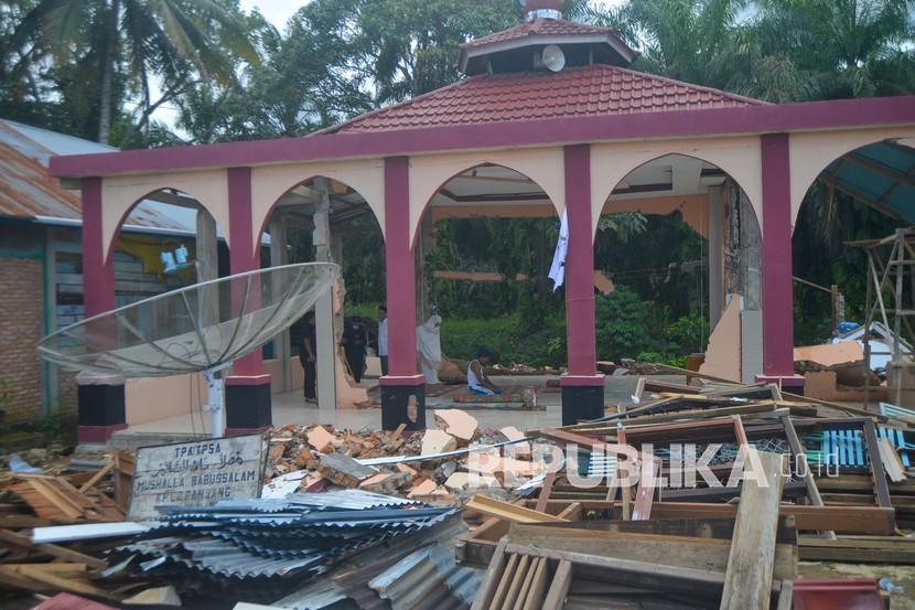 Warga melaksanakan shalat di mushala yang rusak akibat gempa di Kabupaten Pasaman Barat, Sumatera Barat.  Banyak masjid dan mushala yang rusak akibat gempa belum diperbaiki.