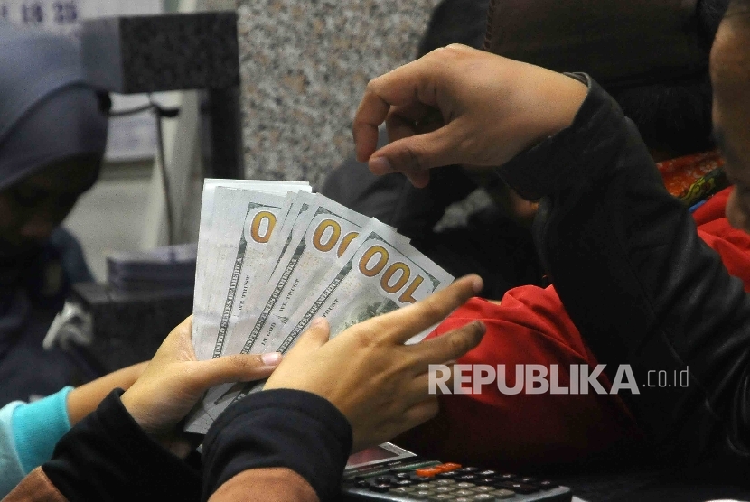  Warga melakukan penukaran mata uang asing di tempat penukaran uang (money changer) di Jakarta, Rabu (11/1).