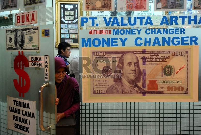 Petugas sedang menghitung uang Dollar di Money Changer, Jakarta, Rabu (7/10). 