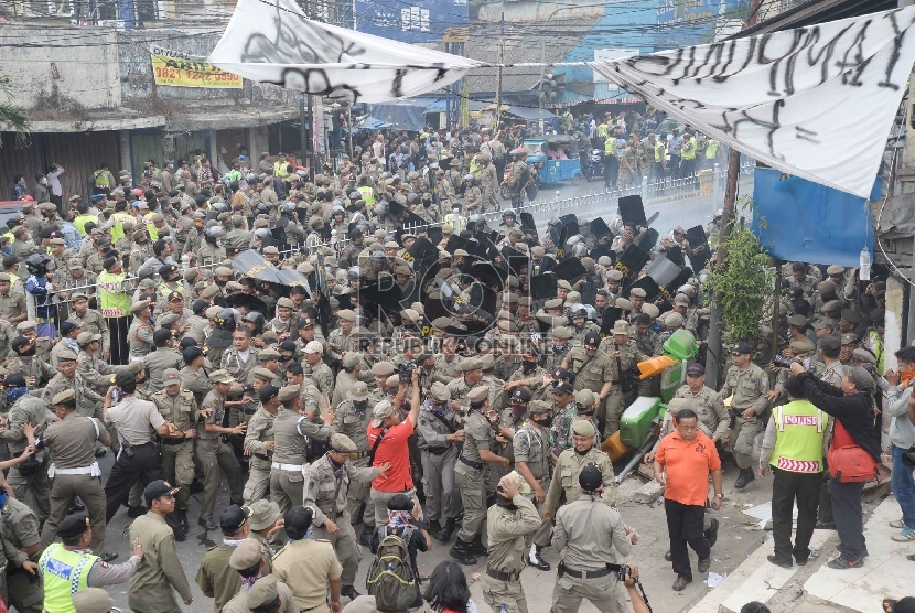 Warga melakukan perlawanan saat Satpol PP melakukan penggusuran pemukiman liar di Kampung Pulo, Jatinegara, Jakarta, Kamis (20/8).   (Republika/Yasin Habibi)