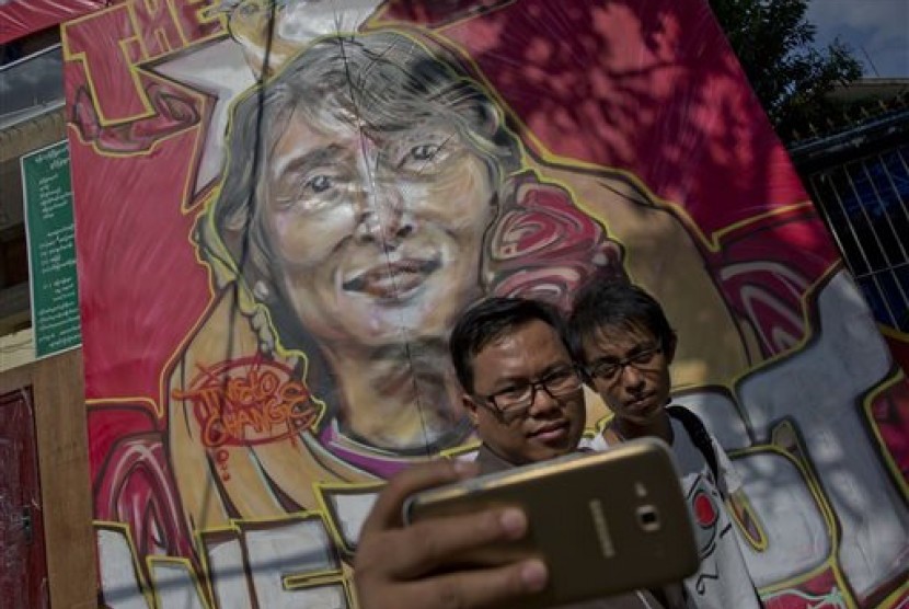 Warga melakukan swafoto dengan latar belakang pemimpin oposisi Myanmar Aung San Suu Kyi di Yangon, Myanmar, Jumat, 13 November 2015. Partai Suu Kyi menang telak dalam pemilu. 