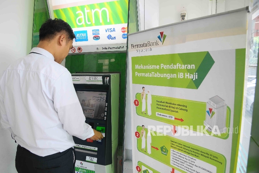 Warga melakukan transaksi meggunakan mesin ATM Bank Permata Syariah di Jakarta, Senin (26/12).(Republika/Agung Supriyanto)