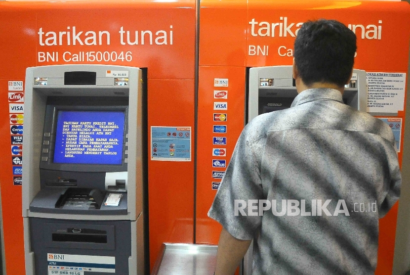  Warga melakukan transaksi menggunakan mesin ATM Bank BNI Syariah. (ilustrasi).