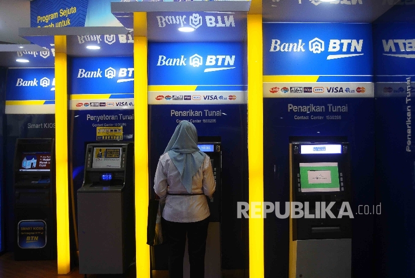 Warga melakukan transaksi menggunakan mesin ATM Bank BTN di Jakarta, Ahad (31/7). (Republika/ Agung Supriyanto)