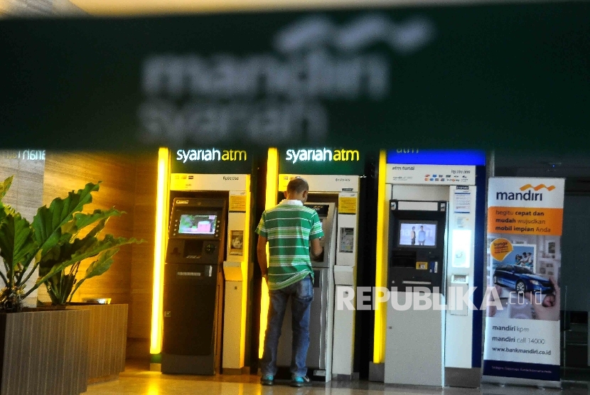  Warga melakukan transaksi menggunakan mesin ATM Bank Syariah Mandiri (BSM) di Jakarta, Ahad (4/12).