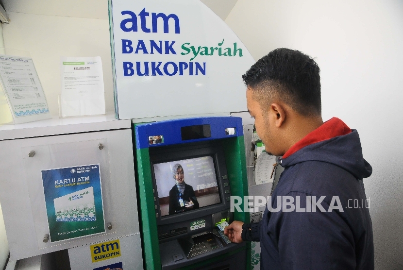  Warga melakukan transaksi menggunakan mesin ATM di Bank Syariah Bukopin, Jakarta, Ahad (5/3).