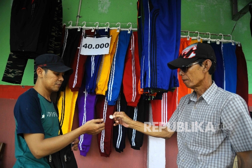  Warga melakukan transaksi pembelian menggunakan Dirham di Pasar Muamalah, Depok, Jawa Barat, Ahad (18/12).