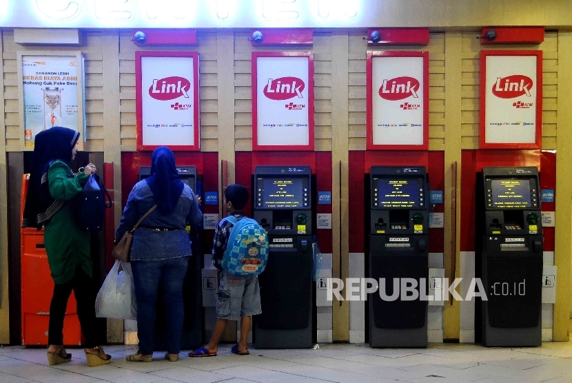 Warga melakukan transkasi menggunakan mesin ATM Himpunan Bank-Bank Milik Ngara (Himbara) di Pasar Tanah Abang, Jakarta, Ahad (9/10).