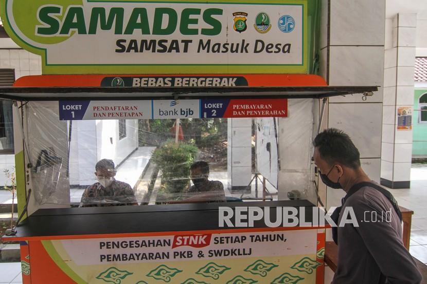 Warga melalukan pembayaran pajak kendaraan di Samsat Masuk Desa (SAMADES) di Kelurahan Tapos, Kota Depok, Jawa Barat, Kamis (14/10/2021). 