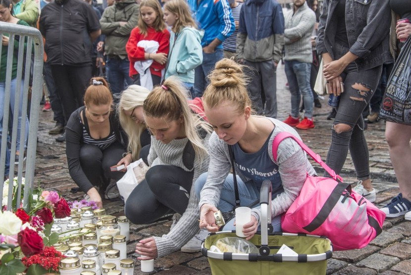 Warga meletakka karangan bunga di lokasi kejadian penusukan di Turku, Finlandia, Sabtu (19/8).