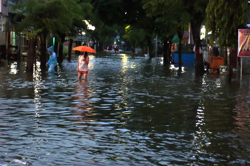 Warga melewati banjir di kawasan Sutojayan, Blitar, Jawa Timur, Senin (17/10/2022). BPBD Jatim mencatat sebanyak 465 jiwa yang berasal dari 13 desa di lima kecamatan terdampak mengungsi di 12 titik pengungsian akibat banjir yang disebabkan meluapnya sejumlah sungai besar di daerah tersebut dampak dari tingginya intensitas curah hujan dalam beberapa hari terakhir. 