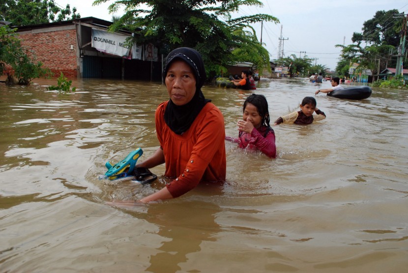 Warga melewati banjir yang merendam rumah di Desa Pulo Lawas Bangkinang, Kabupaten Kampar, Riau (Ilustrasi)