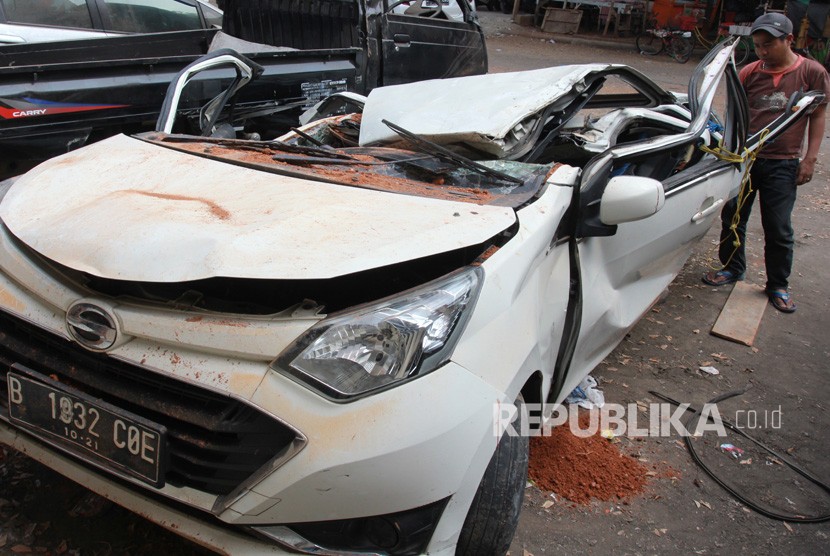 Warga melihat bangkai mobil kecelakaan maut yang hancur tertindih badan truk di Karawaci, Tangerang, Banten, Kamis (1/8/2019). 