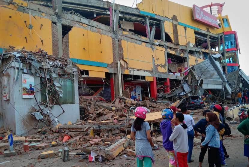 Warga melihat bangunan pusat perbelanjaan yang ambruk akibat gempa di Palu, Sulawesi Tengah, Sabtu (29/9).