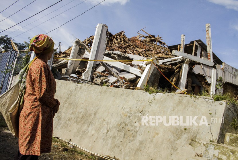 Warga melihat bangunan rusak akibat gempa bumi di kecamatan Kabandungan, Sukabumi, Jawa Barat, Rabu (11/3/2020). 