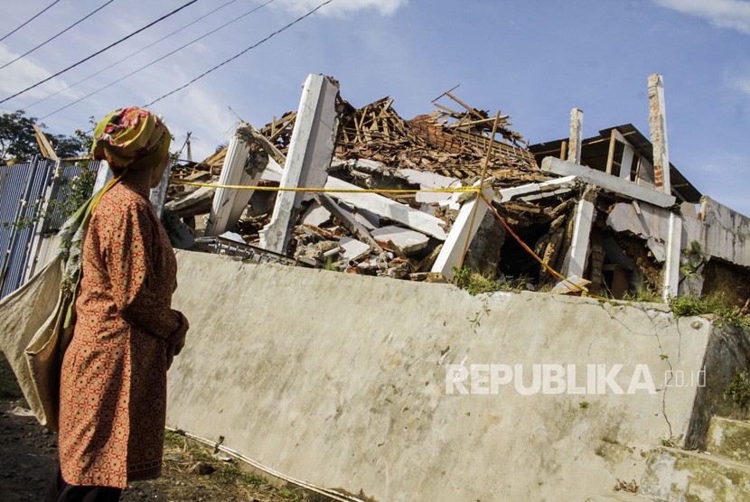 Warga melihat bangunan rusak akibat gempa bumi di kecamatan Kabandungan, Sukabumi (ilustrasi)