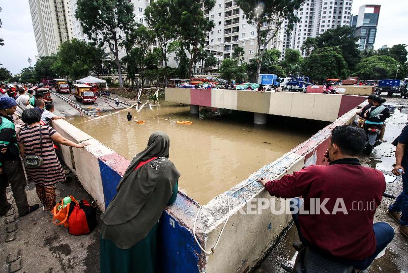 Warga melihat banjir yang menutup Underpass Kemayoran, Jakarta. Masyarakat diminta mewaspadai banjir yang terjadi di underpass atau jalan bawah tanah di persimpangan Jalan HBR, Motik Kemayoran, Jakarta Pusat, Selasa (25/2).