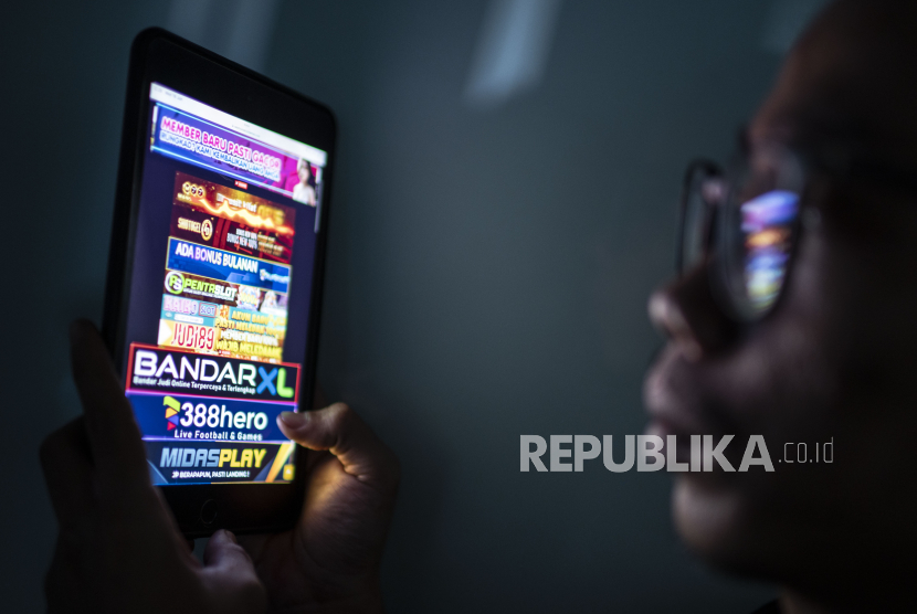  Warga melihat iklan judi online melalui gawainya di Jakarta, Rabu (19/6/2024).