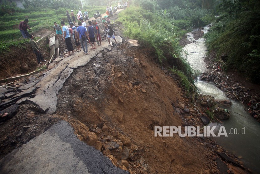 Warga melihat jalan yang terputus akibat longsor di jalur wisata Kabupaten Bogor. (Ilustrasi)