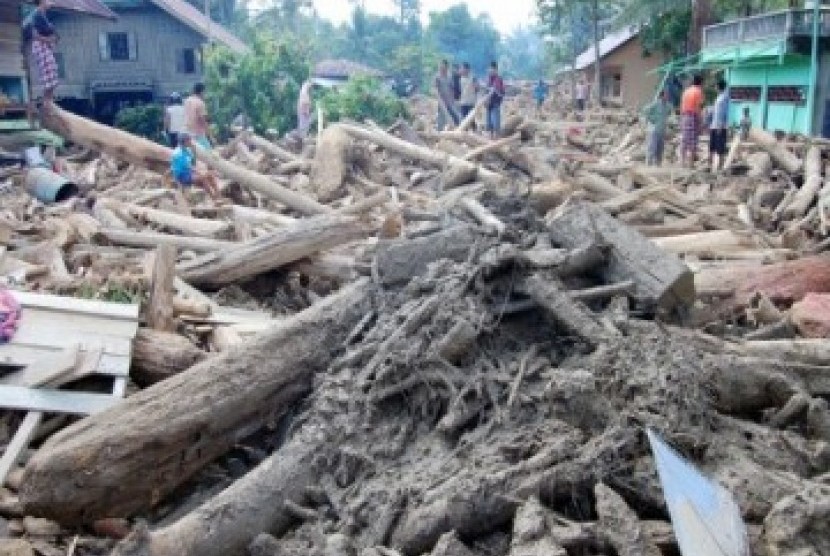 Warga melihat kayu gelondongan ilegal yang berserakan setelah hanyut dibawa banjir bandang di Kecamatan Tangse, Kabupaten Pidie, NAD, Senin (14/3). Perambahan hutan secara membabi buta sejak lima tahun belakangan ini menyebabkan perkampungan di bawah pegun