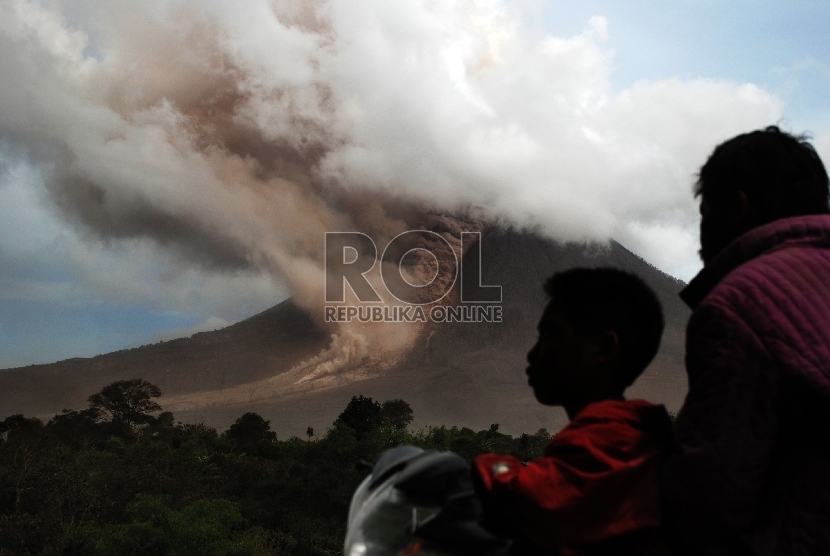 Warga melihat ke arah Gunung Sinabung ketika terjadi luncuran awan panas guguran kubah lava di Namanteran, Karo, Sumatera Utara, Ahad (14/6).(ANTARA FOTO/Rony Muharrman)