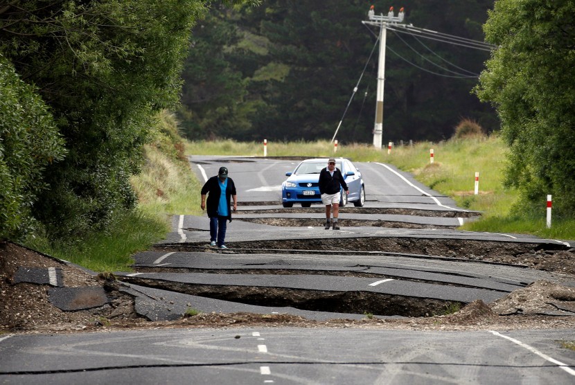 Warga melihat kerusakan akibat gempa di sepanjang jalan dekat Kota Ward, selatan Blenheim, di bagian selatan Pulau Selandia Baru, Senin (14/11).