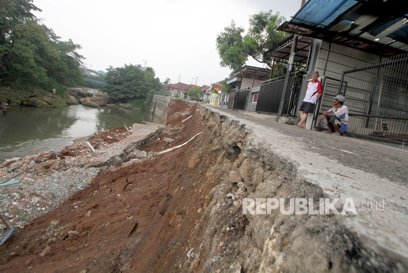 Warga melihat kondisi dinding penahan tanah atau turap yang longsor (ilustrasi)