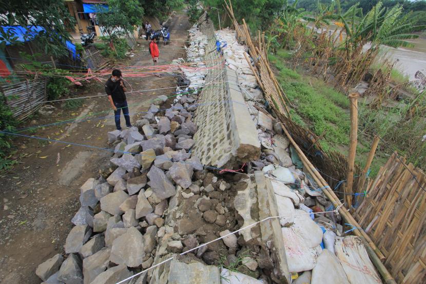 Warga melihat kondisi dinding tanggul Sungai Cimanuk yang mulai roboh di Desa Rambatan Kulon, Lohbener, Indramayu, Jawa Barat. Tanggul tersebut roboh akibat debit air sungai yang besar dan kondisi ini membuat warga khawatir akan terjadi banjir.(Ilustrasi)