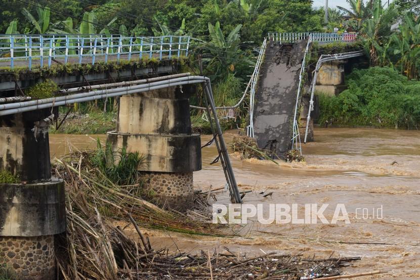 Warga melihat kondisi jembatan yang putus di Sungai Madiun, Kota Madiun, Jawa Timur, Jumat (2/4/2021). Jembatan tersebut putus karena salah satu pilarnya ambruk akibat banjir yang terjadi Kamis (1/4) malam.