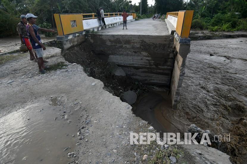 Warga melihat kondisi jembatan yang rusak di Desa Watubula, Kabupaten Sigi, Sulawesi Tengah, Sabtu (11/7/2020). Kerusakan tersebut diakibatkan meningkatnya debit air sungai akibat hujan deras. Rusaknya jembatan tersebut memutus jalur transportasi sejumlah desa di lokasi tersebut. 
