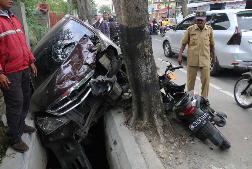 Warga melihat kondisi mobil yang bertabrakan dengan sepeda motor (ilustrasi). Polres Bantul menetapkan sopir mobil penabrak 10 motor sebagai tersangka.