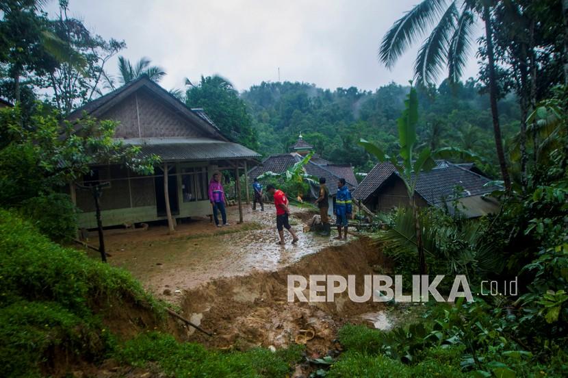 Warga melihat kondisi rumah terdampak longsor di Desa Karangnunggal, Lebak, Banten, Senin (7/12/2020). Sebanyak 13 rumah terdampak tanah longsor yang disebabkan hujan dengan intensitas tinggi sejak Sabtu (5/12). 