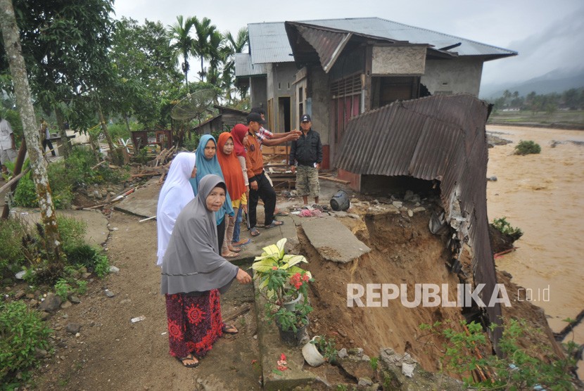 Warga melihat kondisi rumah yang rusak akibat banjir bandang (ilustrasi)