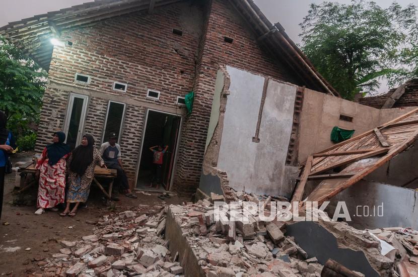 Warga melihat kondisi rumah yang rusak akibat gempa di Kadu Agung Timur, Lebak, Banten, Jumat (14/1/2022). Gempa berkekuatan 6,7 SR tersebut mengakibatkan sejumlah rumah rusak.