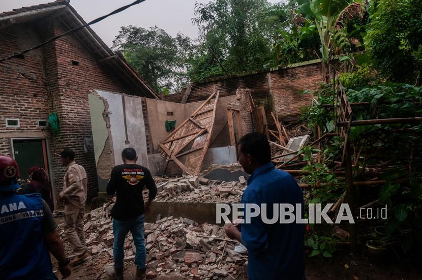 Warga melihat kondisi rumah yang rusak akibat gempa di Kadu Agung Timur, Lebak, Banten, Jumat (14/1/2022). Gempa berkekuatan 6,7 SR tersebut mengakibatkan sejumlah rumah rusak. 