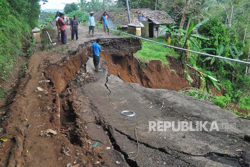 Warga melihat lokasi jalan antar kecamatan yang longsor di Selomanik, Kaliwiro, Wonosobo, Jateng, Selasa (30/1). 